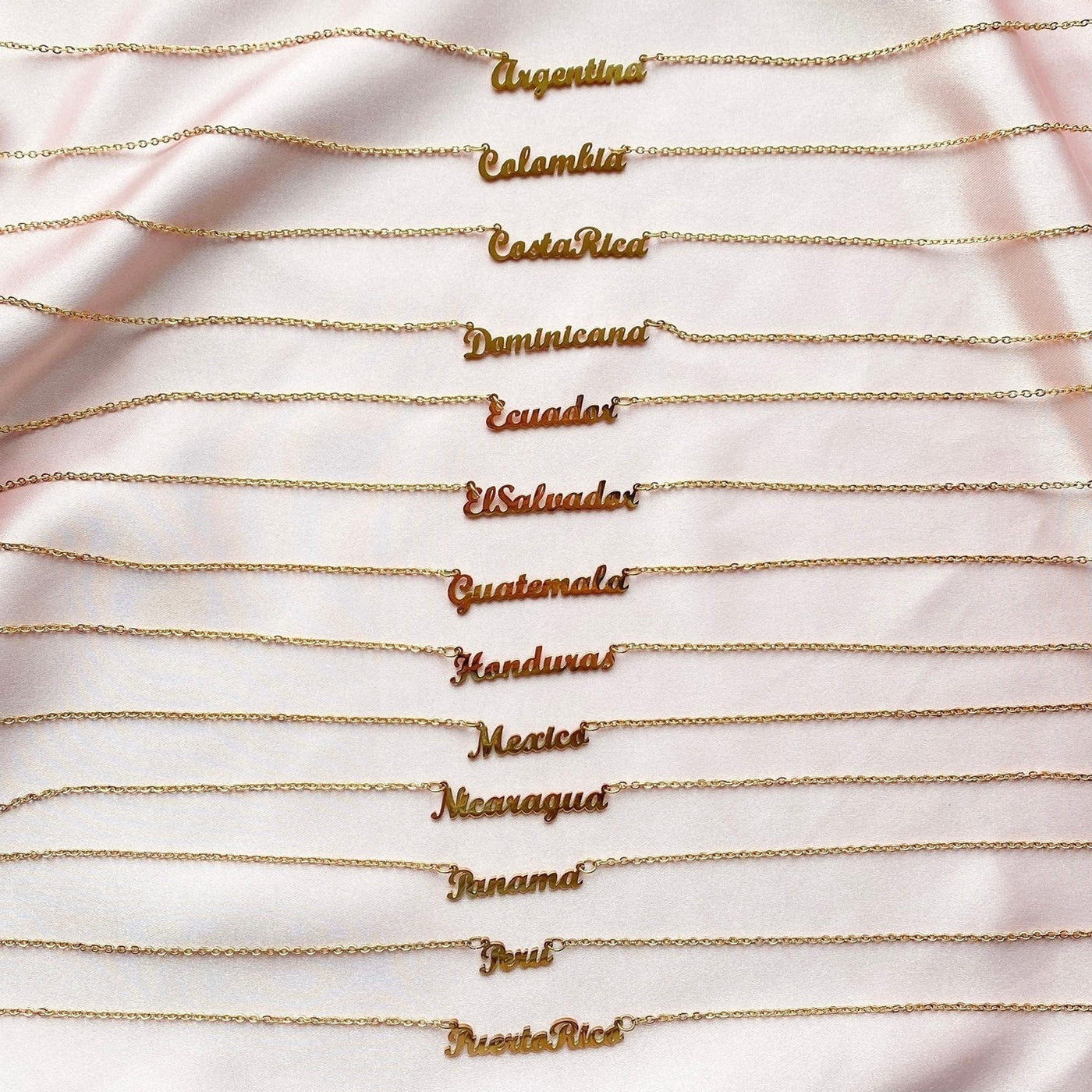 13 gold necklaces with names of Latin American countries on them